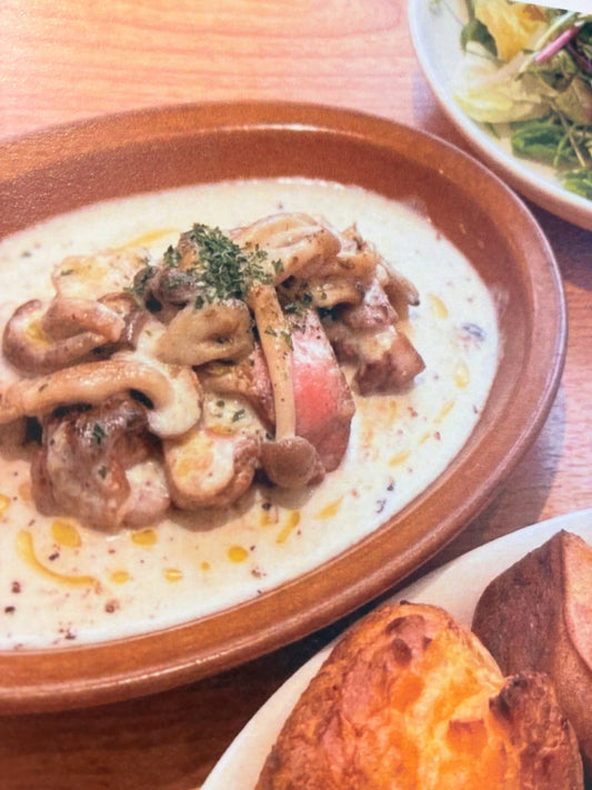 茶色の器に入った豚肉のグリルのきのこクリームソースと、手前のポップオーバー