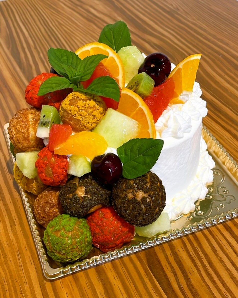 白い生クリームの4号ケーキにカラフルなシューとフルーツを飾ったオーダーケーキ