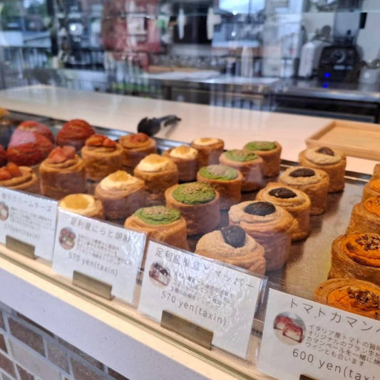 ショーケースに並ぶ、にらや椎茸などをのせたフランと値段カード