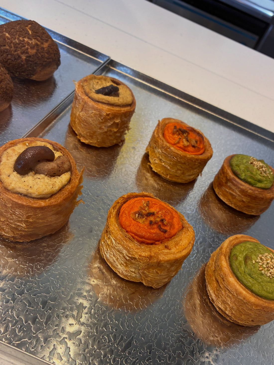 トレーに並んだ樽toパイのフラン。椎茸をのせた物、オレンジ色、緑色のものが見える