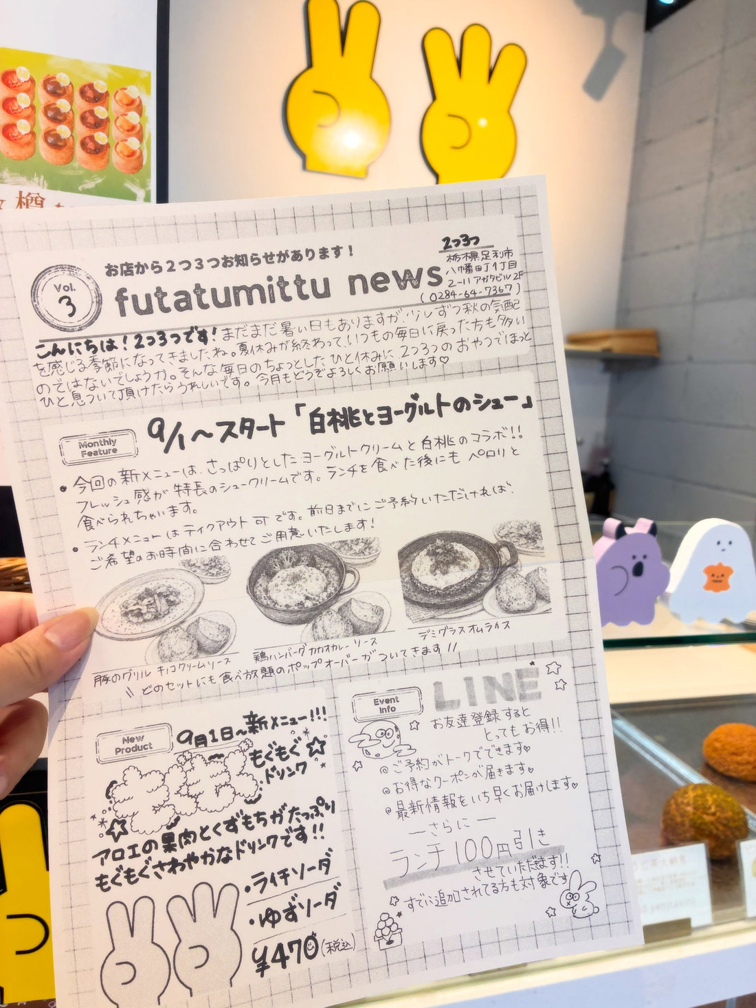 手書き風イラスト入りの2つ3つ新聞vol.3を手に持った写真